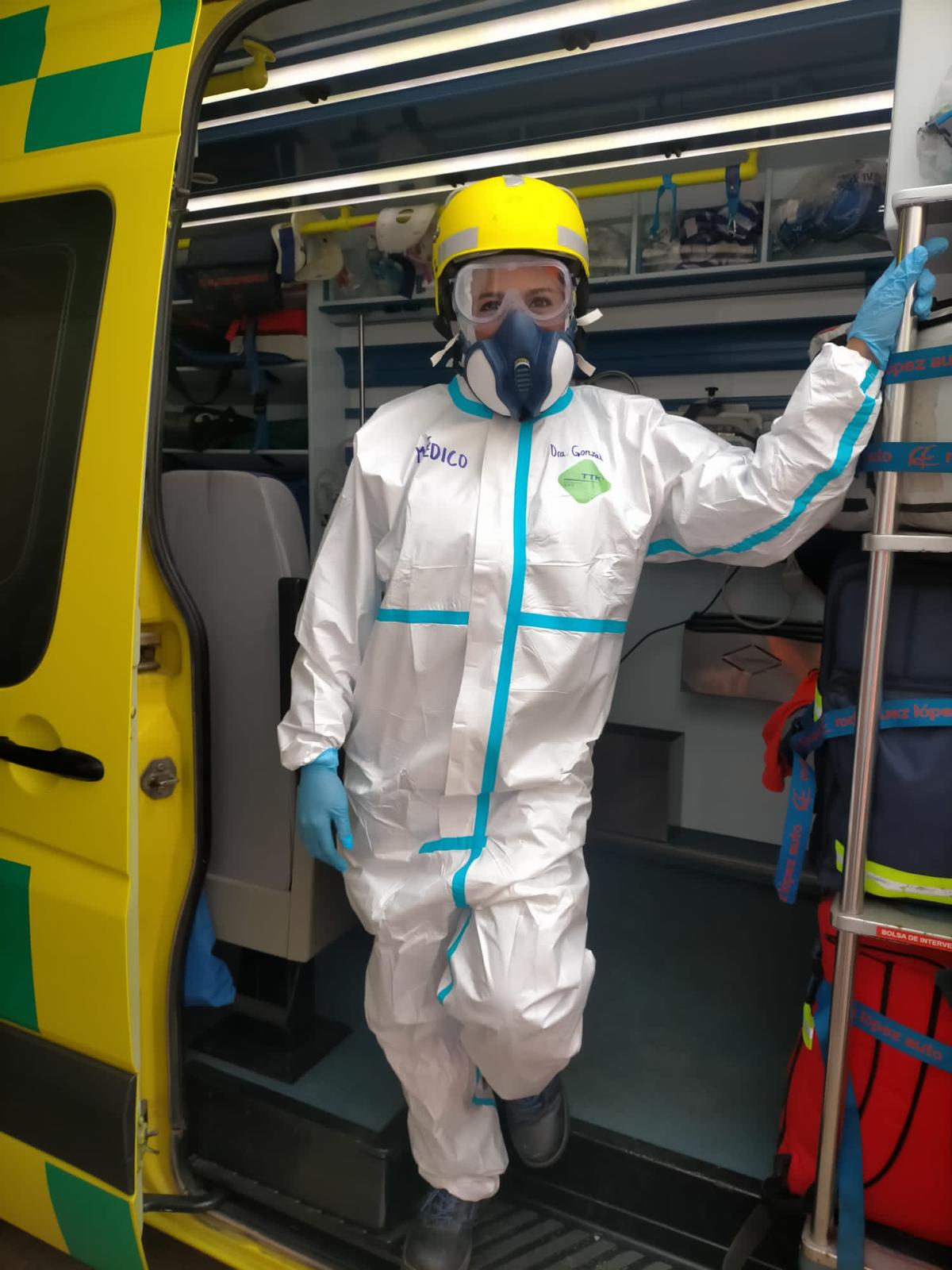 Erika González con equipo de protección individual junto a una ambulancia